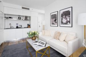 a living room with a white couch and a table at Stunning 2BD Apartment on the 38th Floor in Midtown in New York