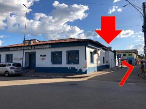 un edificio con una flecha roja delante de él en Hostel Família Carvalho, en Barreirinhas