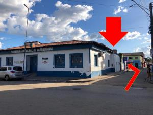 a building with a red arrow in front of it at Hostel Família Carvalho in Barreirinhas