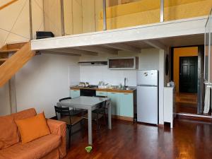 ein Wohnzimmer mit einem Sofa und einem Tisch in der Küche in der Unterkunft Scoglio della Regina, NUOVO, fronte mare, vicino al porto in Livorno