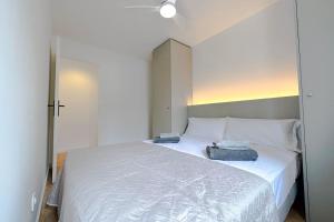 1 dormitorio con 1 cama blanca y 2 toallas en T2 A - Best place in Cala-Montgo beach Apartment with 2 Beds, AC & private Parking, en Torroella de Montgrí