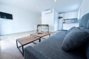 sala de estar con sofá azul y mesa en T2 A - Best place in Cala-Montgo beach Apartment with 2 Beds, AC & private Parking, en Torroella de Montgrí