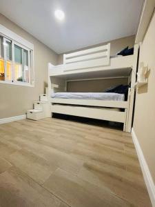 sypialnia z 2 łóżkami piętrowymi i drewnianą podłogą w obiekcie Apartamento Torre Atalaya-Teatinos Malaga capital w Maladze