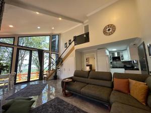 a living room with a couch and a clock on the wall at LexiaDeluxeSuit in Sapanca