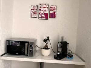 a counter with a microwave and a coffee maker on it at Modern, Cozy apartment with Netflix & Free parking 