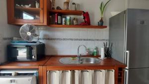 a kitchen with a sink and a refrigerator at Mignon petit appartement indépendant in Mérignac