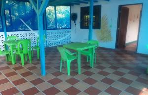 Habitación con mesa verde y sillas en Cabaña RECUERDO Lodge, B & B, en Moñitos