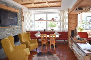 a living room with yellow chairs and a table at Hotel Kleißl in Oberperfuss