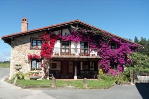 a house with flowers on the side of it at Casa con jardín y terraza privados, cerca del mar in Ea