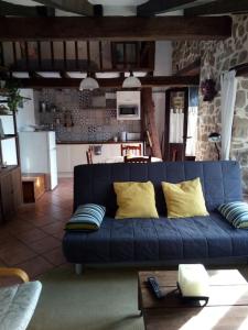 a blue couch with yellow pillows in a living room at Casa Biax jardín y terraza privada junto al mar in Ea +18 photos