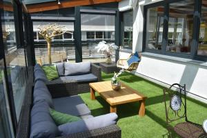 een patio met banken en een tafel op een balkon bij Hotel Kleißl in Oberperfuss