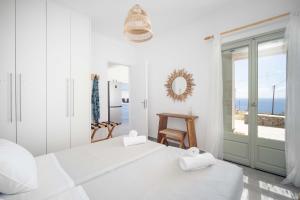a white room with a large white bed and a window at Armonia Villa Serifos in Rámos