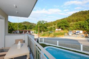 a balcony with a pool and a view of a street at Sunny Memories Apartments in Limenas