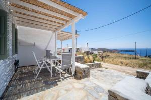 a patio with a table and chairs under a pergola at Armonia Villa Serifos in Rámos