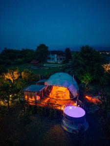 une grande tente éclairée la nuit dans un champ dans l'établissement Sapanca Green Dome, à Sapanca