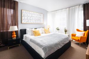 a bedroom with a large bed and a orange chair at Luxurious 1BD Apartment Steps from Times Square in New York