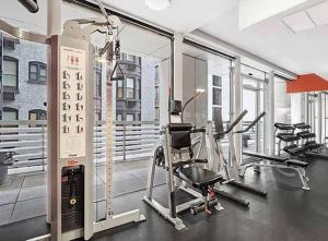un gimnasio con cintas de correr y elípticas en un edificio en Luxurious 1BD Apartment Steps from Times Square en Nueva York