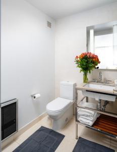 a bathroom with a toilet and a sink and a mirror at Luxurious 1BD Apartment Steps from Times Square in New York