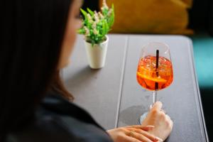 a woman holding a wine glass with a drink at Doanesia Premium Hotel & Spa in Tirana
