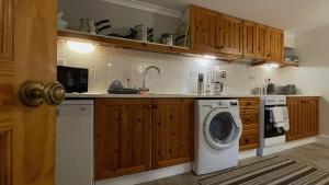 a kitchen with a washing machine and a washer at Kerrowdown Cottage-Self Catering for 4 in the Highlands in Drumnadrochit