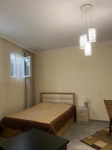 Guest House 27 في تبليسي: غرفة نوم بسرير وطاولة واضاءين