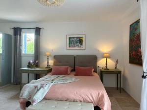1 dormitorio con 1 cama con sábanas rosas y 2 mesas en Au ciel étoilé, en Castillon-du-Gard
