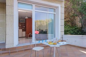 patio con mesa, sillas y ventana en Bella vista studios en Chios