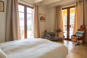 a bedroom with a bed and a chair and a window at Mas la Marchette in Oms