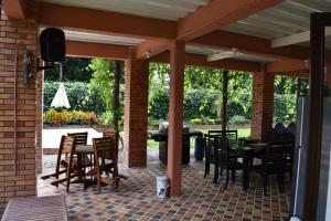 un patio al aire libre con mesas, sillas y TV en Casa hotel la Cachamera en Granada