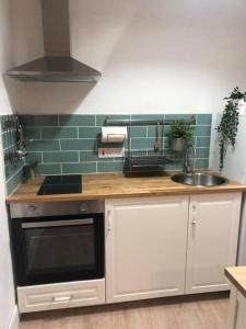 a kitchen with a sink and a stove top oven at Central Sligo Townhouse in Sligo