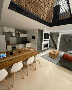 a kitchen and living room with a wooden table and chairs at Zara at Saint Raphael France in Saint-Raphaël