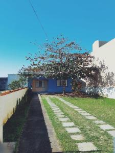 een blauw huis met een boom ervoor bij Temporada no Paraíso in Ilha Comprida