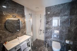 een badkamer met een douche, een toilet en een wastafel bij MELL City Hotel Trabzon in Trabzon