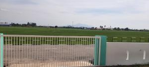 a gate in front of a field with a field at De'Bendang Homestay Pendang in Pendang +9 photos