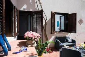 een woonkamer met een tafel, stoelen en bloemen bij Residence Scirocco e Tramontana in Favignana