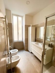 een badkamer met 2 toiletten, een wastafel en een bad bij Torlonia Rooms in Rome
