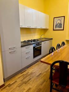 cocina con electrodomésticos blancos y mesa de madera en Residenza del Duca, en Senigallia