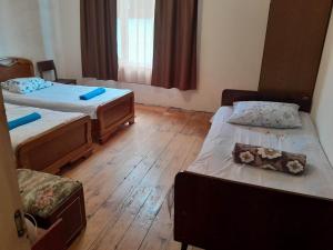 a small room with two beds and a room with at Guesthouse "Kvara"- Mukhuri in Chʼkhorotsqu