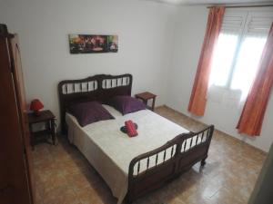 a bedroom with a bed with a red object on it at Vacances Antilles in La Trinité