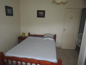 a small bedroom with a bed with a white mattress at Vacances Antilles in La Trinité