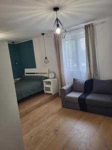 uma sala de estar com um sofá e uma cama em PaulAngela em Avignon
