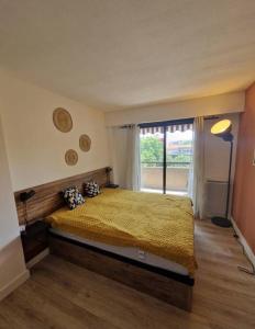 um quarto com uma cama e uma grande janela em Cagnes sur Mer-Spacieux 2 pièces em Cagnes-sur-Mer