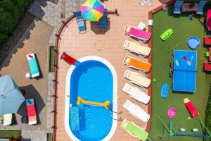 an overhead view of a pool with chairs and an umbrella at Apartment Pool&Garden in Rijeka