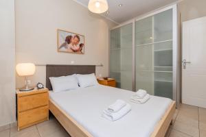 ネオス・マルマラスにあるCristina Apartmentのベッドとタオル2枚のある寝室