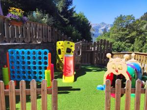 une aire de jeux pour enfants avec une clôture en bois et des jouets dans l'établissement Résidence Les Edelweiss, à Champagny-en-Vanoise