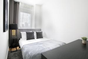 a white bedroom with a bed and a window at Stylish 2BD with Washer and Dryer near Times Square in New York