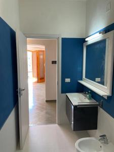 a bathroom with a sink and a blue wall at Colori del Sud - Residence in Mattinata