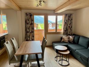 a living room with a couch and a table with chairs at Sporthotel Oberwald in Oberwald