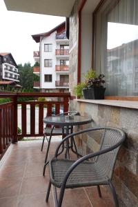 un patio con 2 mesas y sillas en un balcón en GO GO RILA PARK en Borovets