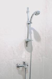 y baño con ducha con cabezal de ducha. en Kubu Indah Homestay Sanur en Sanur